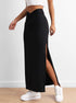 Black long skirt with high side slit and twisted waistband, worn with white sneakers, highlighting the skirt's design details