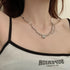 Silver pearl-accented branch-link necklace with a gemstone pendant worn on a woman’s neck