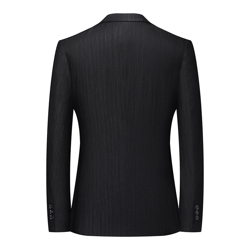 Back view of black textured blazer showing tailored fit, clean lines and functional sleeve buttons at cuff