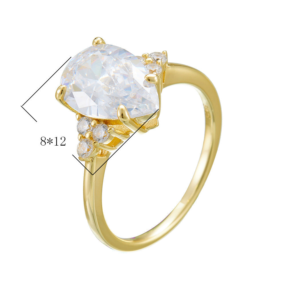 A gold pear-shaped engagement ring with cubic zirconia center stone and small diamond accents, showing 8x12mm dimension marker