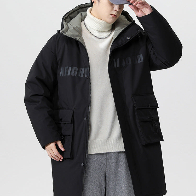 A man adjusting his gray cap while wearing black NEIGHBORHOOD parka with white turtleneck and gray sweatpants against white background