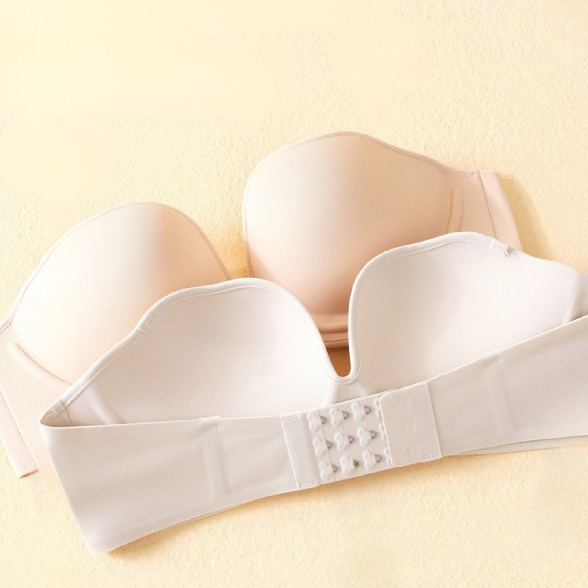 Strapless push-up bra with a soft "W" support structure, removable straps, and non-slip band, displayed open to show interior design and hook closure.