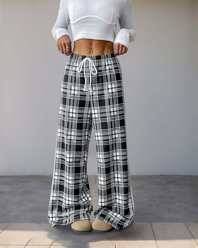 High-waisted plaid wide-leg pants with a relaxed fit and an adjustable drawstring waistband, styled with a white fitted crop top.
