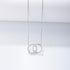Silver interlocking circles necklace with one diamond-encrusted circle and one plain circle pendant on fine chain against white surface