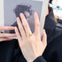 Gold lightning bolt ring shown on hand holding a black and white portrait photo