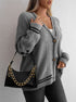 Gray cable knit cardigan with star details and black trim, accessorized with black croc-effect handbag