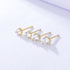 Four gold prong-set diamond stud earrings in ascending sizes displayed in a row on white surface