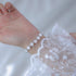 White crystal beaded bracelet with silver spacers shown against lace detail