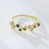 A woman wearing 925 stamped gold rainbow bubble ring with bezel-set gemstones photographed on white surface