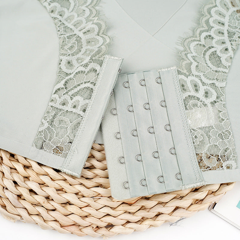 Close-up of light gray hook-and-eye closure with lace trim detail, displayed on woven placemat