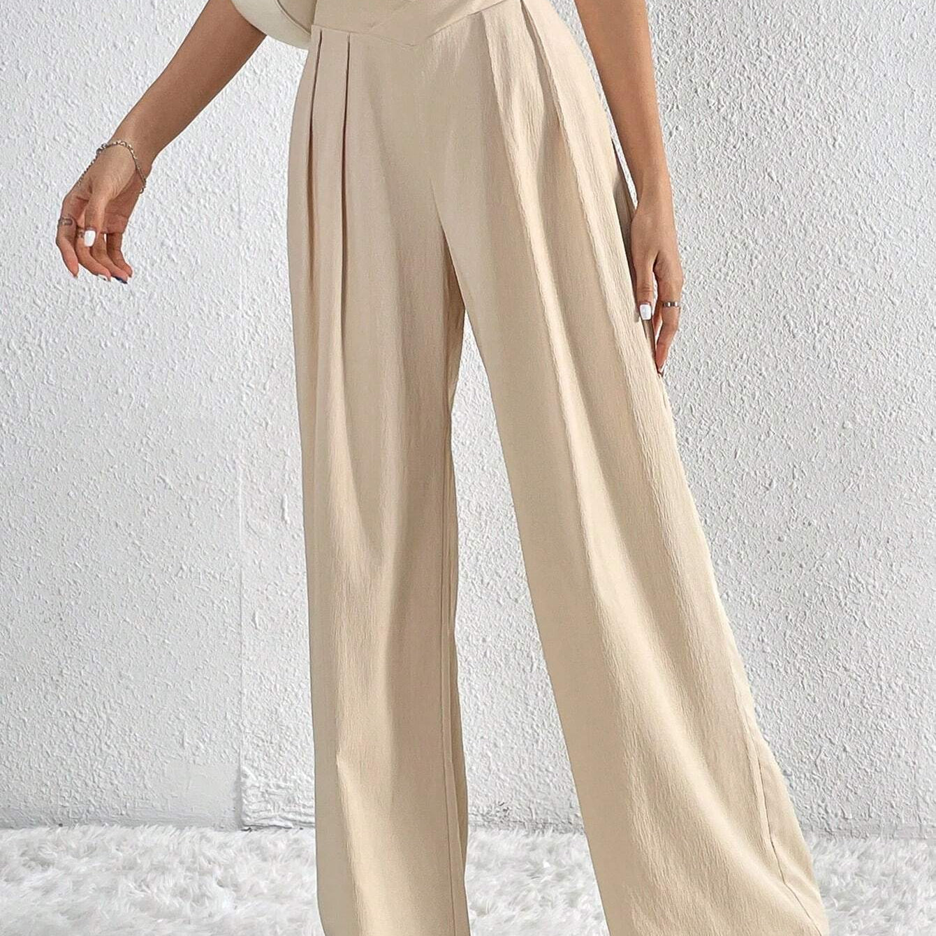 Front view of beige pleated wide-leg trousers styled with white crop top.
