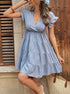 Side view of a woman in a baby blue ruffle sleeve babydoll dress, wearing a woven bag and hair accessories.