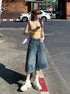 Side view, mid-step pose – Washed denim culotte shorts with casual wide-leg silhouette.