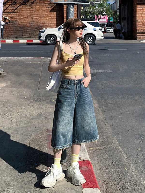 Side view, mid-step pose – Washed denim culotte shorts with casual wide-leg silhouette.