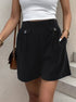 Structured black shorts with front pockets, white top, and brown leather bag for versatile outfit