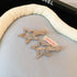 Silver-tone hollow star hair clips with a polished finish, displayed on a soft fabric surface.
