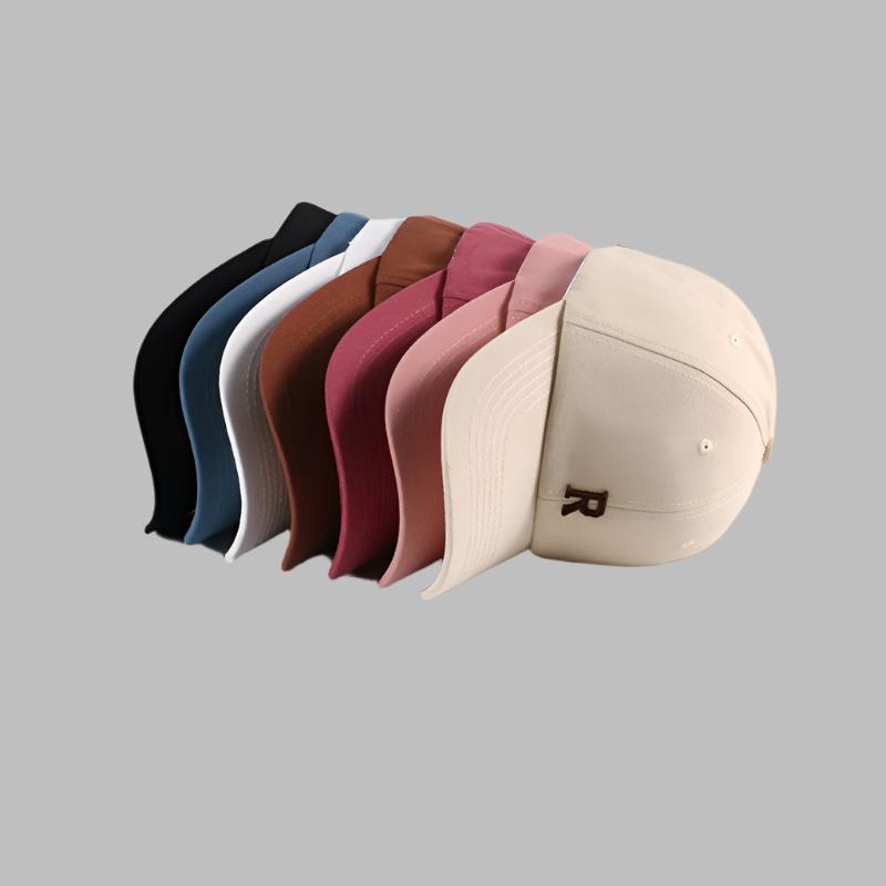 Six baseball caps fanned out showing color range from black to beige, each featuring 'R' logo embroidery and curved brim