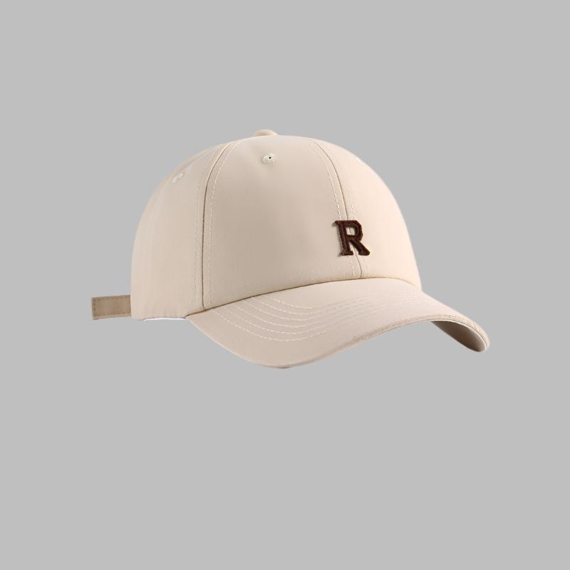 Beige baseball cap with brown 'R' logo embroidery, adjustable strap and structured crown design