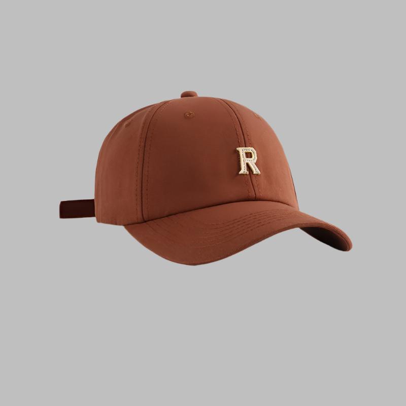 Brown baseball cap with metallic gold 'R' logo, structured six-panel design and adjustable strap