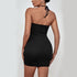 Back view of model wearing black ribbed mini dress with halter neck tie closure, showing fitted silhouette