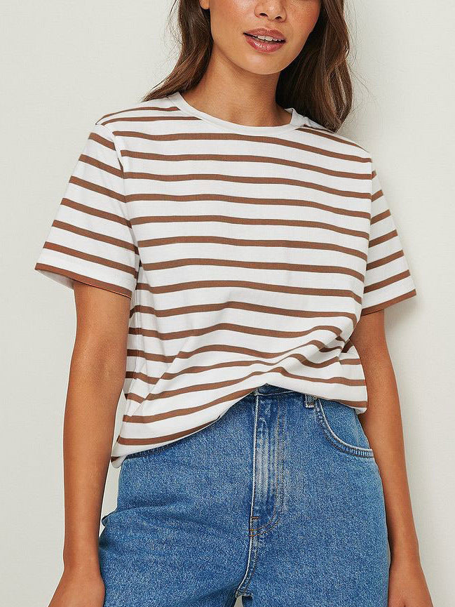 Woman in brown and white striped tee, blue denim skirt, warm smile