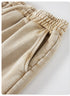 A close-up of beige shorts highlighting the side pocket and ruched waistband, with visible stitching details