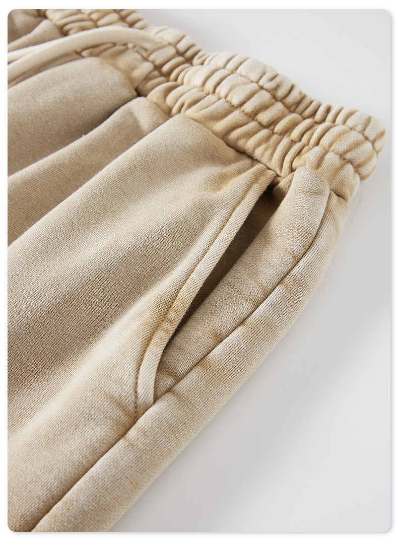 A close-up of beige shorts highlighting the side pocket and ruched waistband, with visible stitching details