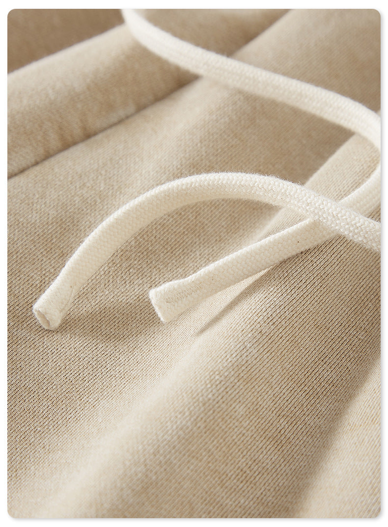 A macro shot of beige drawstring shorts, showing the soft fabric texture and white drawstring ends