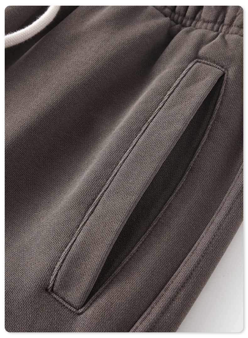 Close-up detail of gray sweatpants pocket with stitching visible against the fabric