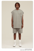 Male model wearing light gray oversized muscle tee and matching shorts with white Air Force 1 sneakers