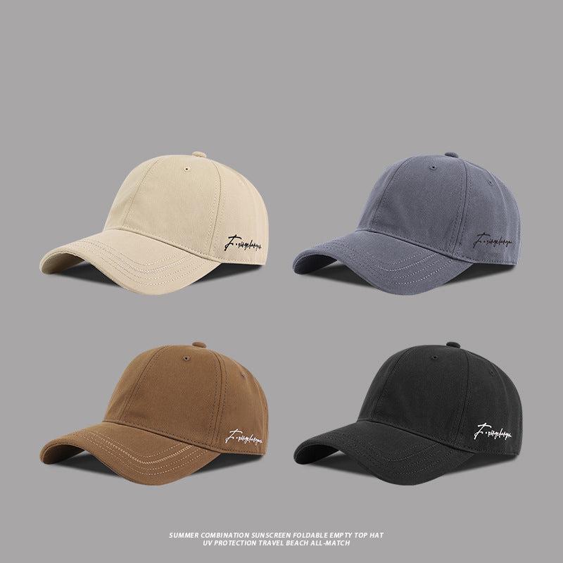 Set of four baseball caps in khaki, black, blue, and brown, each featuring embroidered signature logos