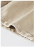 A close-up of the hem of beige washed shorts, featuring clean stitching and a slightly folded edge