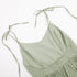 A sage green linen dress bodice with tie straps and V-neckline photographed flat against white background