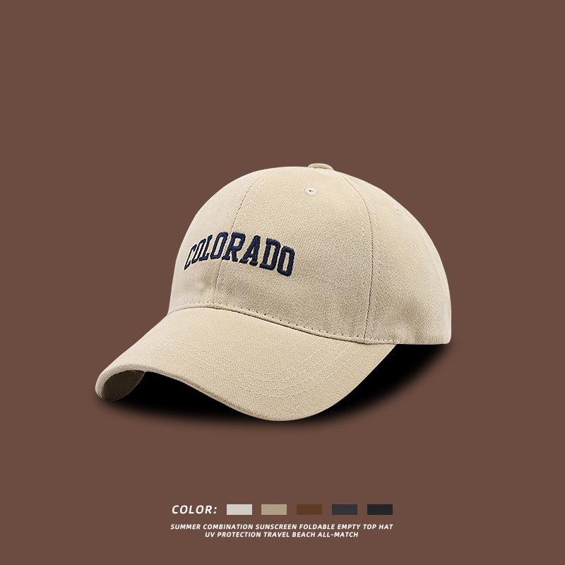 Beige baseball cap with navy COLORADO embroidery displayed against brown background with product features listed beneath