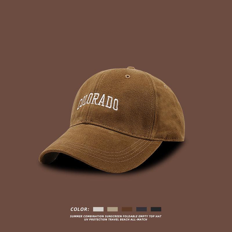 Tan baseball cap with white COLORADO embroidery displayed against brown background with color options and UV protection features