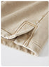 A detailed shot of a side vent on beige washed shorts, revealing reinforced stitching and a layered design