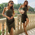 Model wearing olive green ruched dress with nude clutch, styled with gold necklaces and heeled sandals