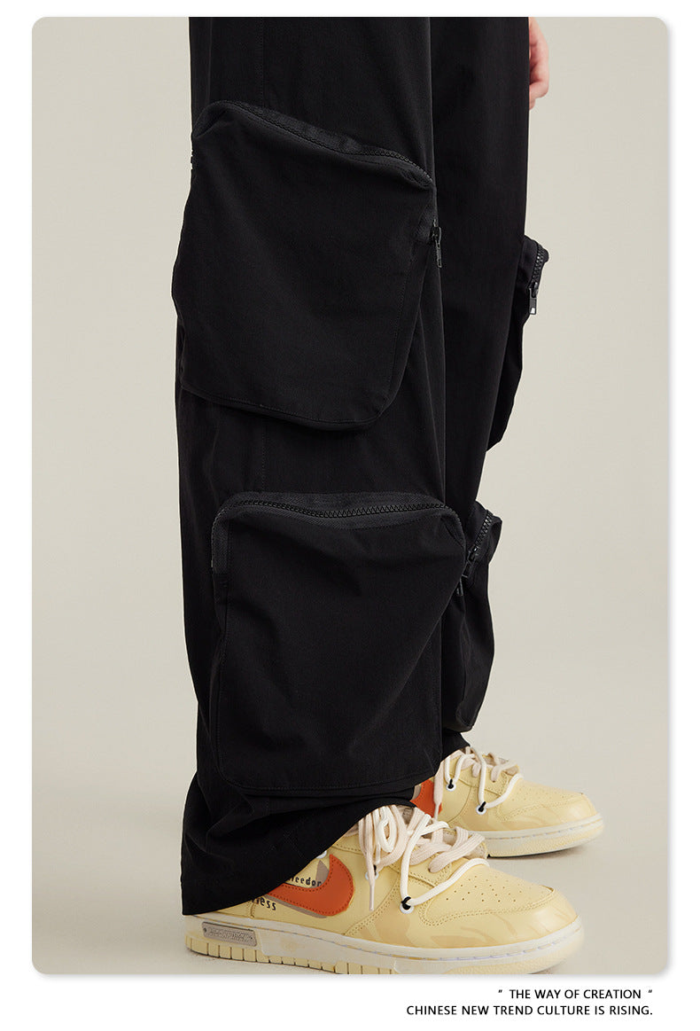 Close-up of utility pocket on black cargo pants with zipper closure