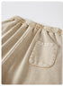A close-up of the back pocket on beige washed shorts, featuring a simple rectangular design and visible stitching