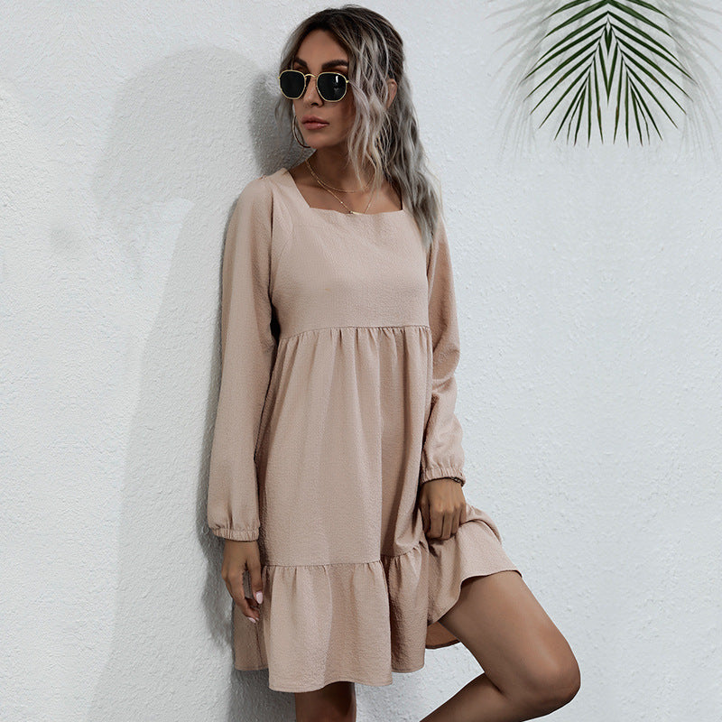 Detailed view of beige babydoll dress highlighting relaxed fit and tiered hemline