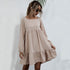 Beige babydoll dress with long sleeves and tiered skirt, creating effortless and comfortable look