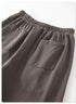 Close-up of charcoal gray sweatpants showing elastic waistband and back pockets on white background.