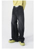 A model wears faded black wide-leg jeans with a "NOT" belt, a yellow sweater, and chunky black-and-green boots, posing casually