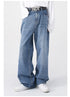 A model wears blue wide-leg jeans with a black "NOT" belt, a white long-sleeve shirt, and white sneakers, posing casually