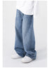 A back-side angle of blue wide-leg jeans, highlighting the loose fit and high waist, worn with a white shirt and sneakers