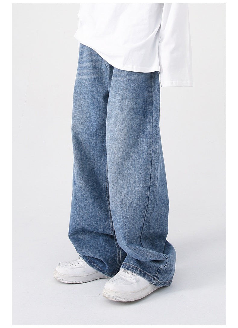 A back-side angle of blue wide-leg jeans, highlighting the loose fit and high waist, worn with a white shirt and sneakers