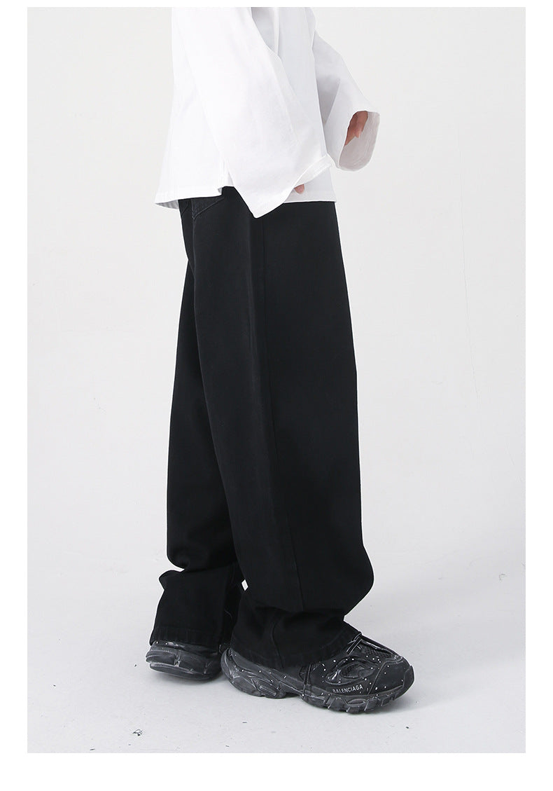 A side view of black wide-leg jeans with a high waist and relaxed fit, paired with a white long-sleeve shirt and black sneakers