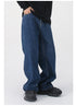A close-up of dark blue wide-leg jeans, highlighting the high waist and loose silhouette, styled with a black top and sneakers