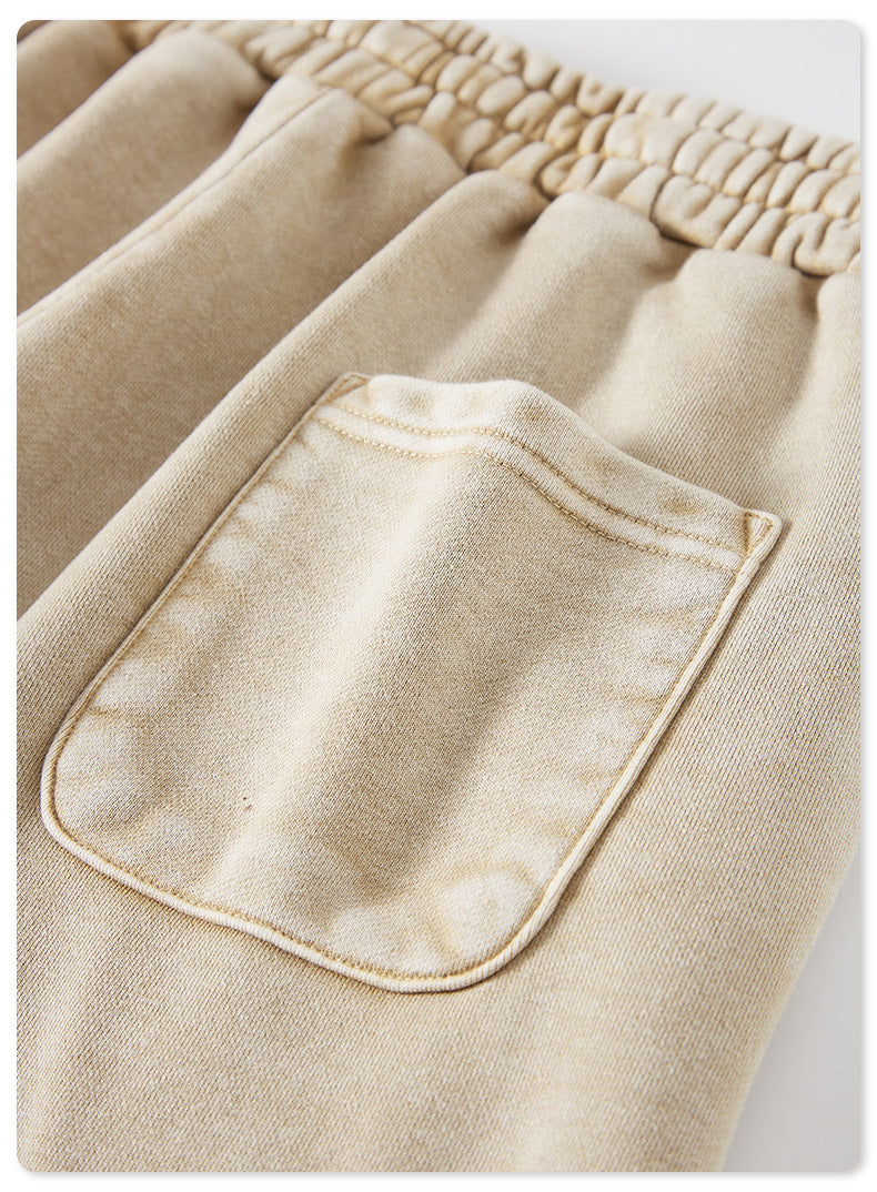 A macro view of the back pocket on beige shorts, showing a slight puffiness in the fabric and reinforced stitching
