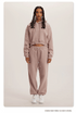 Dusty Pink Sweatshirt and Joggers Set – Model in a soft pink cropped hoodie and sweatpants, paired with white sneakers